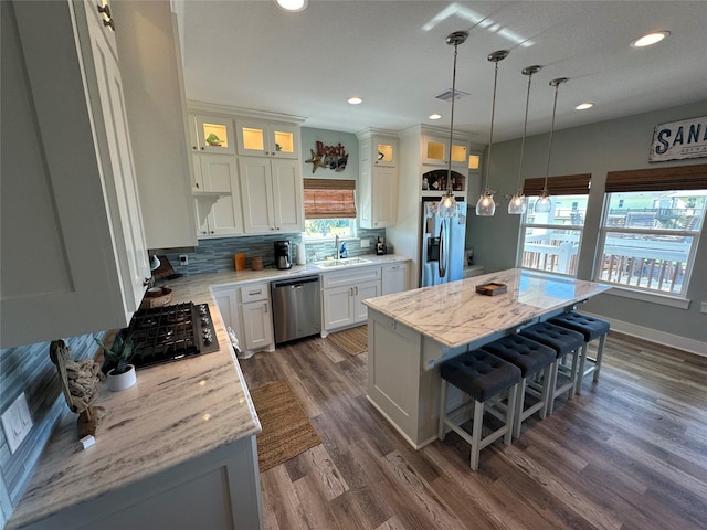 2429 Sand Bar Ln, Crystal Beach, TX 77650 - kitchen featuring appliances with stainless steel finishes, a kitchen breakfast bar, backsplash, a center island, and white cabinets