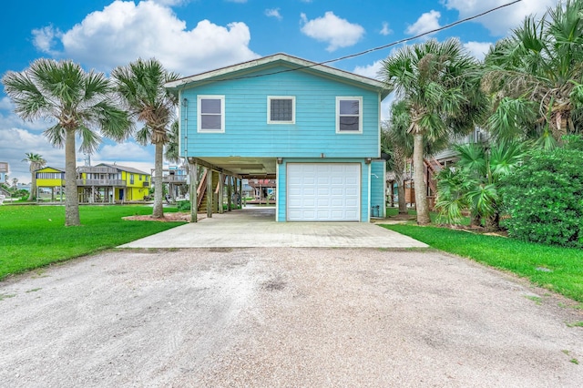 211 Anchor Dr, Freeport, TX 77541 - beach home with driveway, a carport, stairs, a garage, and a front lawn