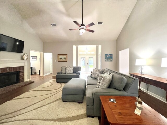 1407 Evening Cloud Ct, Katy, TX 77450 - living area with vaulted ceiling, a ceiling fan, wood finished floors, a brick fireplace, and french doors