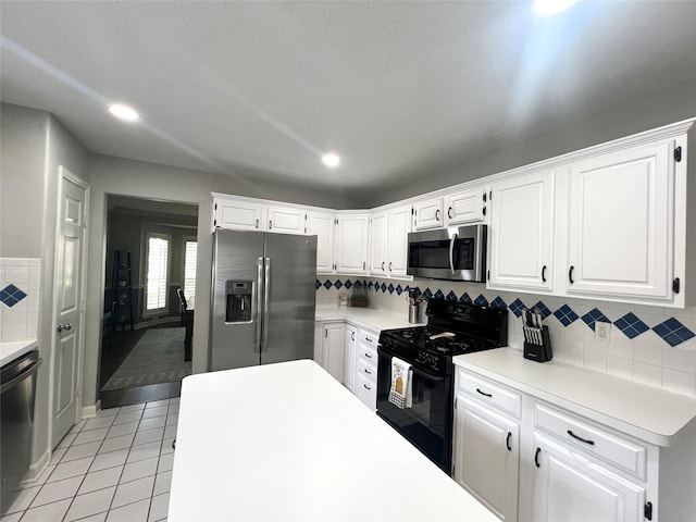 1407 Evening Cloud Ct, Katy, TX 77450 - kitchen with appliances with stainless steel finishes, light tile patterned floors, light countertops, white cabinets, and recessed lighting