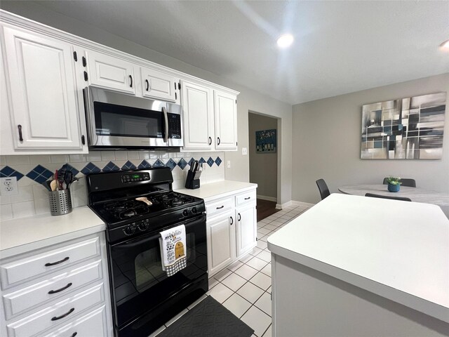 1407 Evening Cloud Ct, Katy, TX 77450 - kitchen featuring stainless steel microwave, black gas range, backsplash, light countertops, and light tile patterned flooring