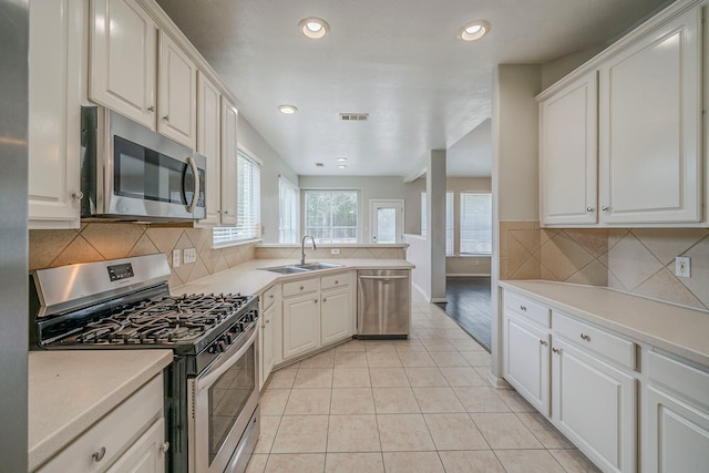 13430 Magnolia Crest Ln, Houston, TX 77070 - kitchen featuring stainless steel appliances, tasteful backsplash, light countertops, light tile patterned floors, and a peninsula
