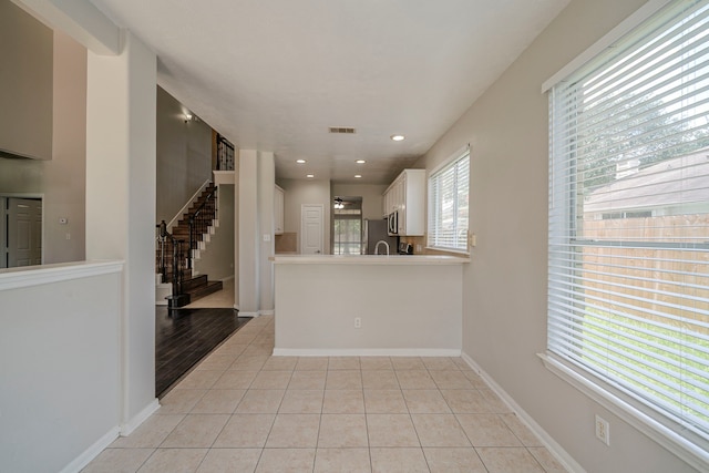 13430 Magnolia Crest Ln, Houston, TX 77070 - kitchen with light tile patterned flooring, recessed lighting, white cabinets, appliances with stainless steel finishes, and a peninsula