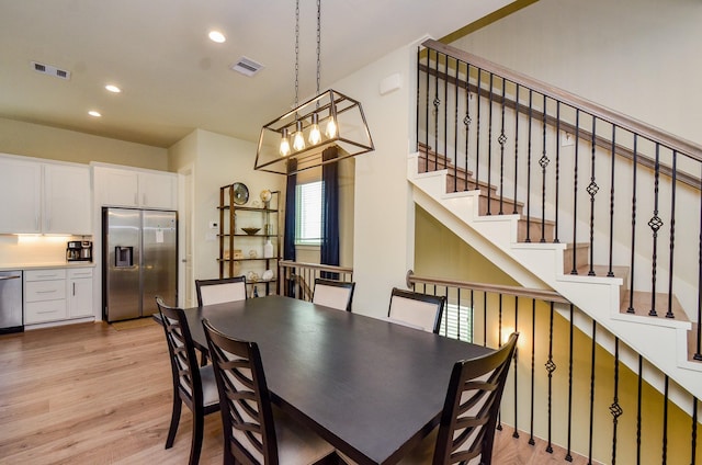 4915 Ave J, Houston, TX 77011 - dining room featuring light wood-type flooring, recessed lighting, stairway, and a chandelier