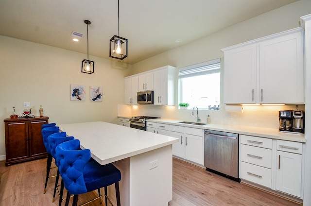 4915 Ave J, Houston, TX 77011 - kitchen featuring stainless steel appliances, light wood-style flooring, tasteful backsplash, a kitchen island, and a kitchen breakfast bar