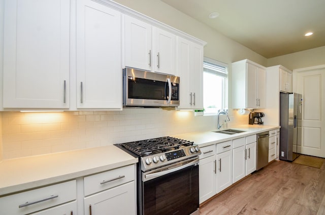 4915 Ave J, Houston, TX 77011 - kitchen featuring appliances with stainless steel finishes, light wood-style floors, white cabinetry, light countertops, and recessed lighting