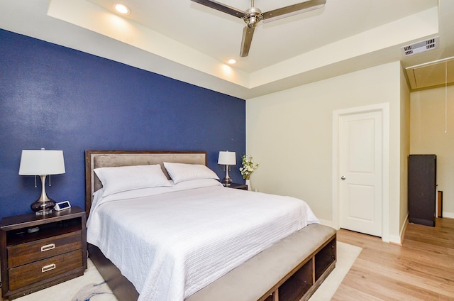 4915 Ave J, Houston, TX 77011 - bedroom featuring attic access, light wood-style flooring, a raised ceiling, recessed lighting, and a ceiling fan
