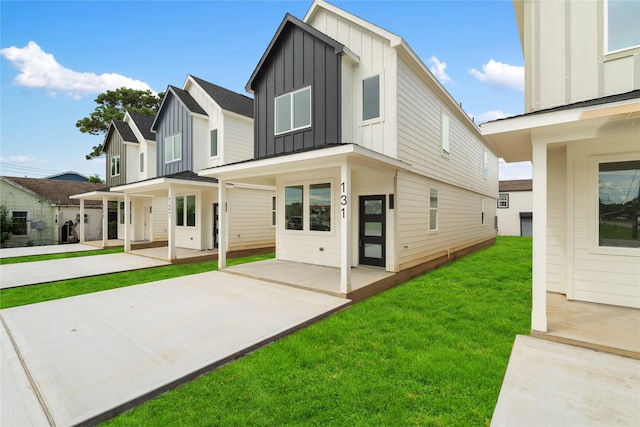 131 S Virginia Ave, La Porte, TX 77571 - view of front of property with board and batten siding, a front lawn, and a patio
