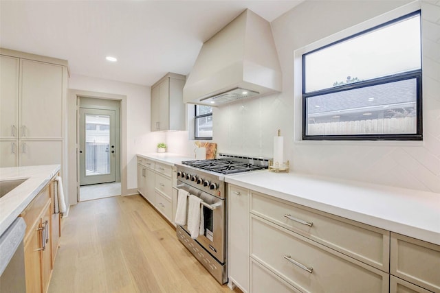 2831 Shadowdale Dr, Houston, TX 77043 - kitchen featuring appliances with stainless steel finishes, custom exhaust hood, light wood finished floors, light countertops, and cream cabinetry
