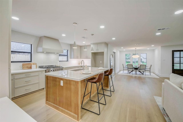 2831 Shadowdale Dr, Houston, TX 77043 - kitchen featuring custom range hood, light wood-style flooring, a kitchen island with sink, pendant lighting, and recessed lighting