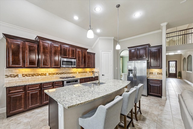 19427 Stanton Lake Dr, Cypress, TX 77433 - kitchen with stainless steel appliances, backsplash, crown molding, arched walkways, and hanging light fixtures