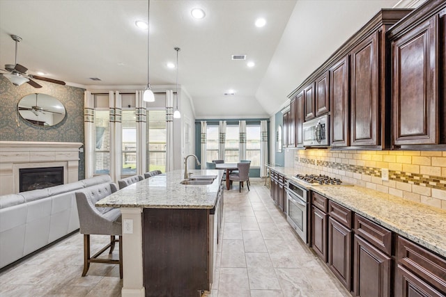 19427 Stanton Lake Dr, Cypress, TX 77433 - kitchen with appliances with stainless steel finishes, open floor plan, ceiling fan, a kitchen bar, and light stone countertops