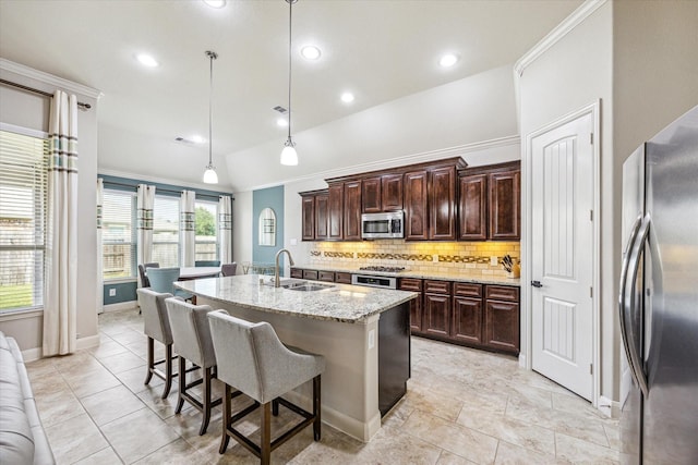19427 Stanton Lake Dr, Cypress, TX 77433 - kitchen featuring appliances with stainless steel finishes, backsplash, a breakfast bar area, an island with sink, and light stone counters