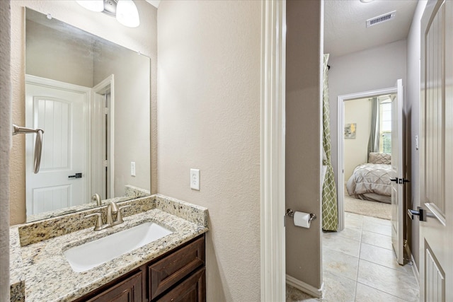 19427 Stanton Lake Dr, Cypress, TX 77433 - bathroom featuring vanity, connected bathroom, tile patterned floors, and a textured wall