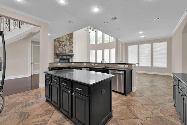 3403 Wooded Ln, Conroe, TX 77301 - kitchen with stainless steel dishwasher, a center island, dark cabinets, ceiling fan, and crown molding