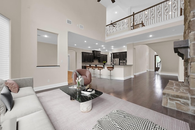 3403 Wooded Ln, Conroe, TX 77301 - living room with arched walkways, dark wood-style flooring, a high ceiling, and a ceiling fan