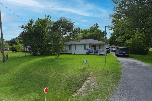 2104 Westward Ln, Marque, TX 77568 - ranch-style house featuring a front yard, a porch, and driveway