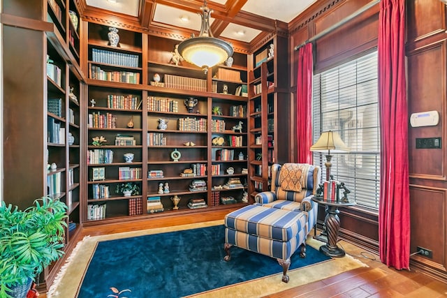 7826 Camden Hollow Ln, Humble, TX 77396 - sitting room featuring wood finished floors, wall of books, beamed ceiling, coffered ceiling, and ornamental molding