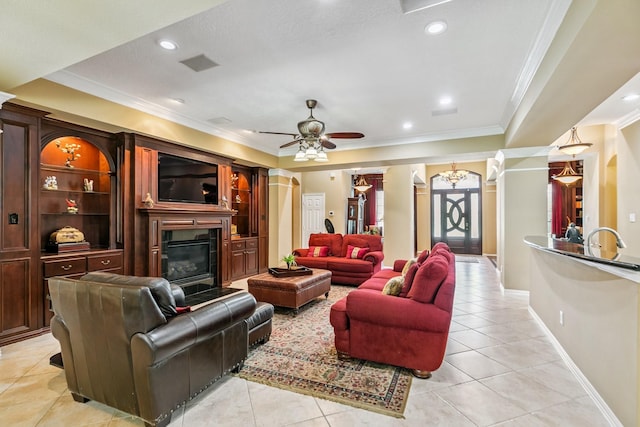 7826 Camden Hollow Ln, Humble, TX 77396 - living area with crown molding, light tile patterned flooring, ceiling fan, a glass covered fireplace, and recessed lighting