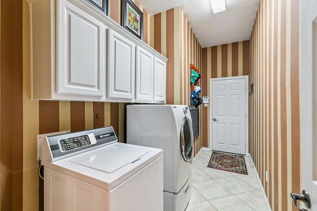7826 Camden Hollow Ln, Humble, TX 77396 - washroom featuring wallpapered walls, washing machine and clothes dryer, cabinet space, a textured ceiling, and light tile patterned flooring