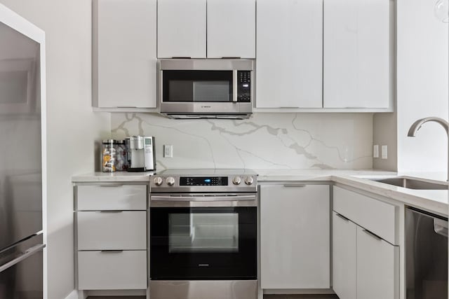 3600 Montrose Blvd Unit 209, Houston, TX 77006 - kitchen featuring appliances with stainless steel finishes, white cabinets, decorative backsplash, and light stone counters