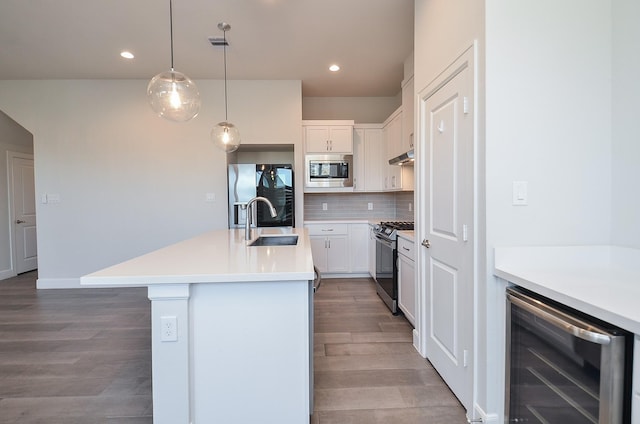 9577 Neuens Rd Unit F, Houston, TX 77080 - kitchen featuring wine cooler, stainless steel appliances, wood finished floors, tasteful backsplash, and an island with sink