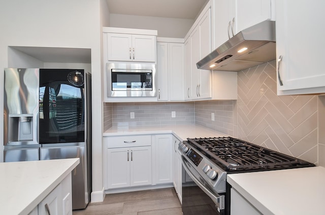9577 Neuens Rd Unit F, Houston, TX 77080 - kitchen with appliances with stainless steel finishes, wall chimney range hood, light countertops, and white cabinetry