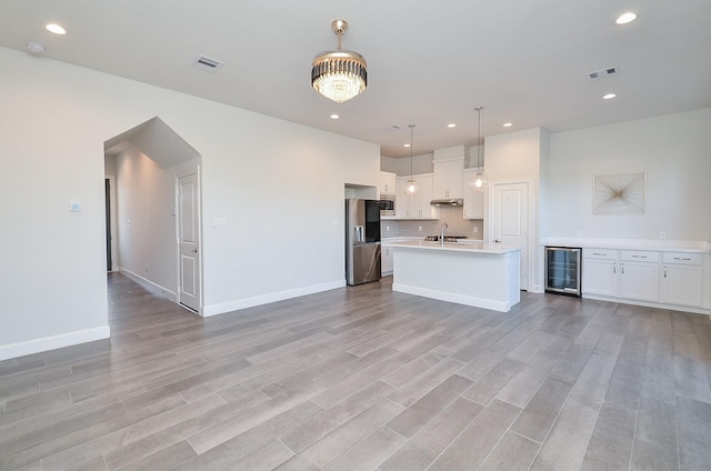 9577 Neuens Rd Unit F, Houston, TX 77080 - kitchen with appliances with stainless steel finishes, beverage cooler, light countertops, tasteful backsplash, and under cabinet range hood