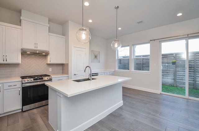 9577 Neuens Rd Unit F, Houston, TX 77080 - kitchen with stainless steel gas range, dark wood-style floors, under cabinet range hood, light countertops, and backsplash