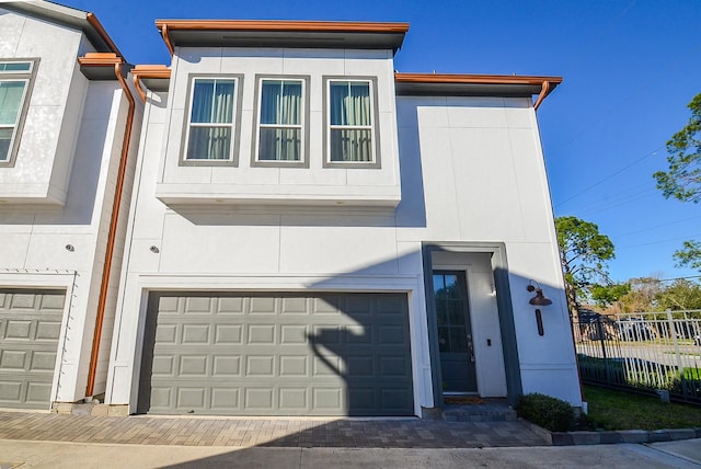 9577 Neuens Rd Unit F, Houston, TX 77080 - view of front of house featuring a garage, stucco siding, and decorative driveway