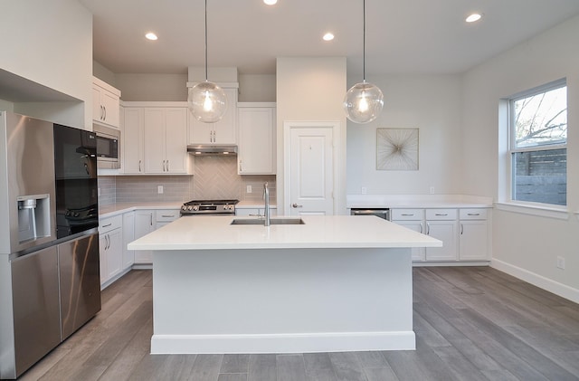 9577 Neuens Rd Unit F, Houston, TX 77080 - kitchen with appliances with stainless steel finishes, light countertops, decorative backsplash, wood finished floors, and white cabinetry