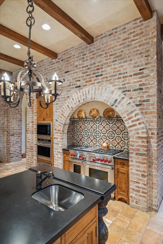 3 E Rivercrest Dr, Houston, TX 77042 - kitchen featuring stainless steel appliances, dark countertops, beam ceiling, brown cabinets, and stone tile flooring