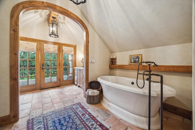 3 E Rivercrest Dr, Houston, TX 77042 - bathroom featuring vaulted ceiling, a freestanding tub, stone tile floors, and vanity