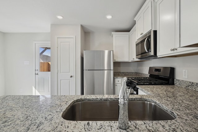 396 Tejas Trl, Waller, TX 77484 - kitchen with stainless steel appliances, light stone countertops, white cabinetry, and recessed lighting