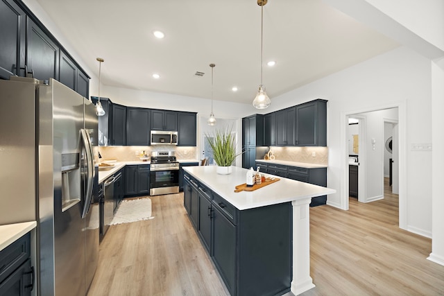 10722 Sky Creek Ln, Beasley, TX 77417 - kitchen with stainless steel appliances, decorative backsplash, a kitchen island, light wood finished floors, and recessed lighting