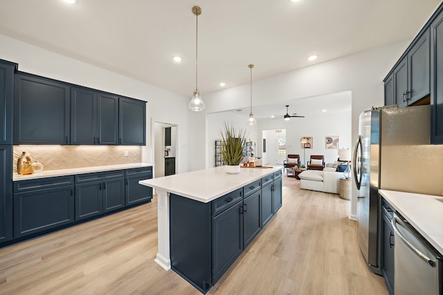 10722 Sky Creek Ln, Beasley, TX 77417 - kitchen featuring stainless steel appliances, a ceiling fan, light wood-style flooring, tasteful backsplash, and open floor plan