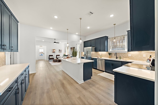 10722 Sky Creek Ln, Beasley, TX 77417 - kitchen featuring appliances with stainless steel finishes, backsplash, open floor plan, light wood-type flooring, and recessed lighting