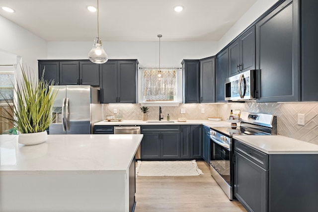 10722 Sky Creek Ln, Beasley, TX 77417 - kitchen with stainless steel appliances, light wood-type flooring, tasteful backsplash, light countertops, and recessed lighting