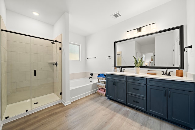 10722 Sky Creek Ln, Beasley, TX 77417 - full bathroom featuring double vanity, a garden tub, wood finished floors, and a stall shower