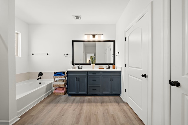 10722 Sky Creek Ln, Beasley, TX 77417 - full bathroom featuring double vanity, wood finished floors, and a bath
