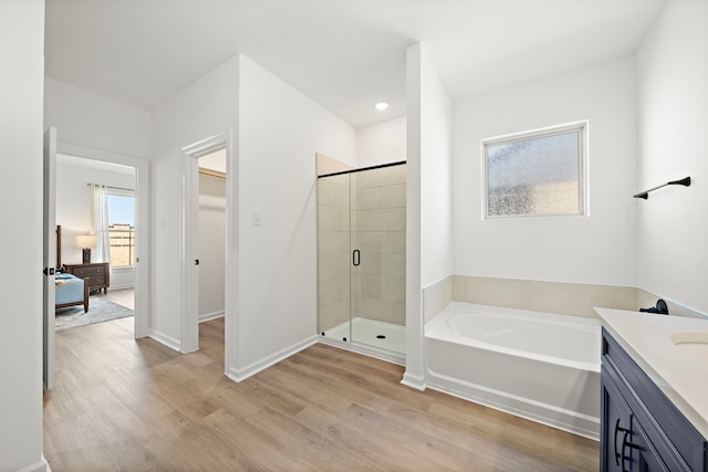 10722 Sky Creek Ln, Beasley, TX 77417 - full bathroom featuring a stall shower, wood finished floors, a bath, vanity, and a walk in closet