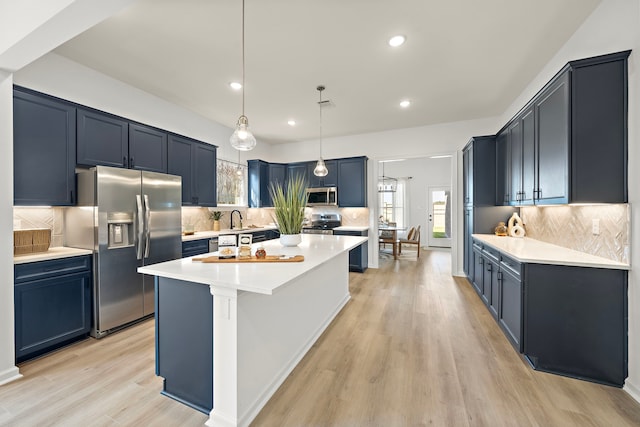 10722 Sky Creek Ln, Beasley, TX 77417 - kitchen featuring appliances with stainless steel finishes, backsplash, light countertops, light wood-type flooring, and recessed lighting
