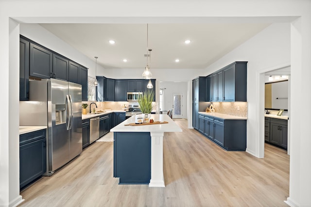 10722 Sky Creek Ln, Beasley, TX 77417 - kitchen featuring stainless steel appliances, light countertops, a center island, light wood finished floors, and recessed lighting