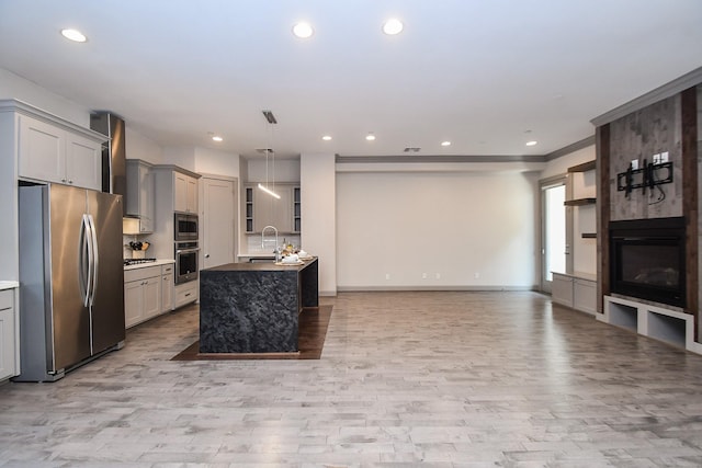 4292 Childress St, Houston, TX 77005 - kitchen featuring appliances with stainless steel finishes, light wood-type flooring, gray cabinets, open floor plan, and recessed lighting