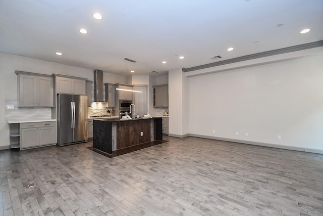 4292 Childress St, Houston, TX 77005 - kitchen featuring appliances with stainless steel finishes, wall chimney exhaust hood, wood finished floors, gray cabinetry, and recessed lighting