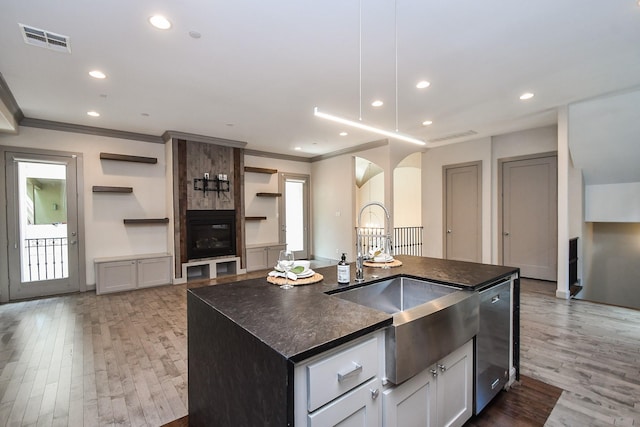 4292 Childress St, Houston, TX 77005 - kitchen with dark countertops, ornamental molding, stainless steel dishwasher, arched walkways, and light wood-type flooring