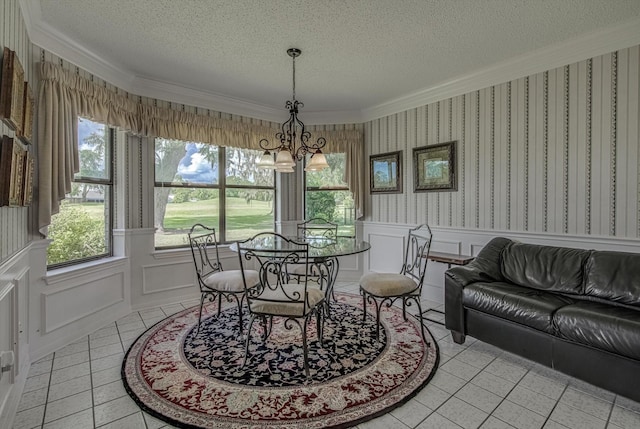 332 N Amherst Dr, West Columbia, TX 77486 - dining area with crown molding, healthy amount of natural light, a textured ceiling, wainscoting, and a chandelier