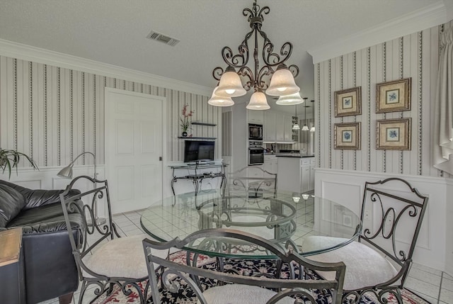 332 N Amherst Dr, West Columbia, TX 77486 - dining area with wallpapered walls, ornamental molding, a chandelier, light tile patterned flooring, and wainscoting
