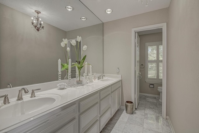 332 N Amherst Dr, West Columbia, TX 77486 - bathroom featuring marble look tile flooring, double vanity, a chandelier, and recessed lighting
