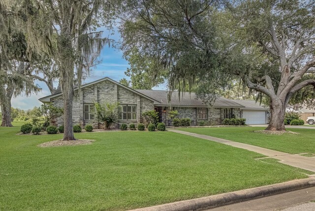 332 N Amherst Dr, West Columbia, TX 77486 - view of front of property with an attached garage, stone siding, a front yard, and concrete driveway